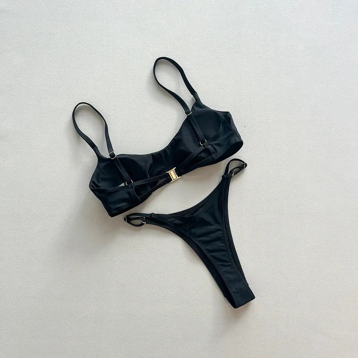 Black two-piece push-up bikini set with gold clasp and adjustable straps; thong bikini bottoms.