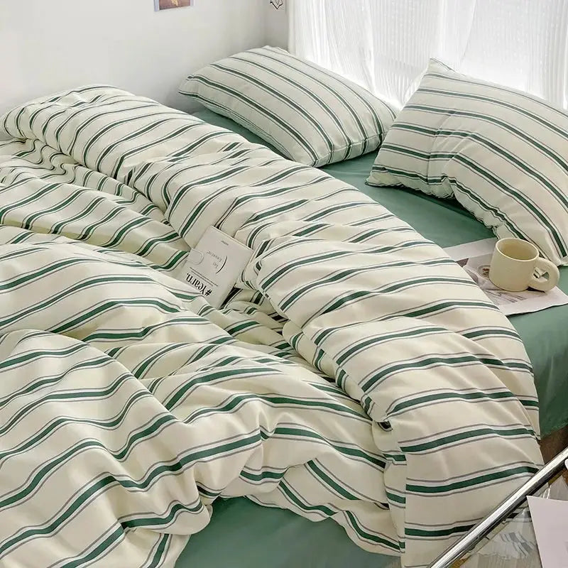 Duvet cover and four-piece bed sheet set by Simples Market in red and blue striped washed cotton bedding on a bed