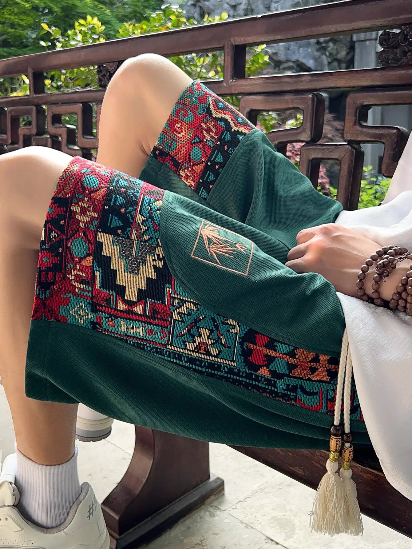 Men's ethnic embroidery pattern shorts with pockets and drawstring, Simples Market green with colorful panels.