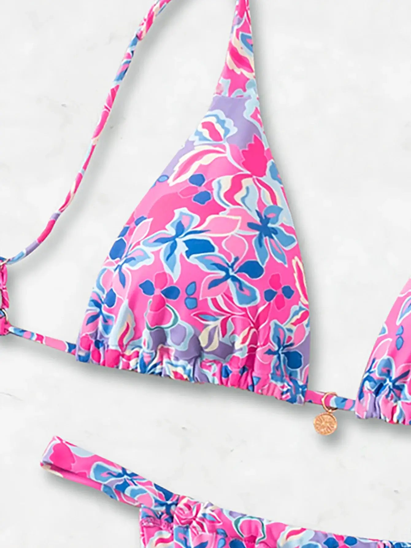 Triangle bikini set in pink floral print with blue and purple accents; matching top and bottom with ties
