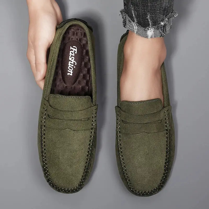 Pair of green suede men's loafers, slip-on driving shoes with visible stitching