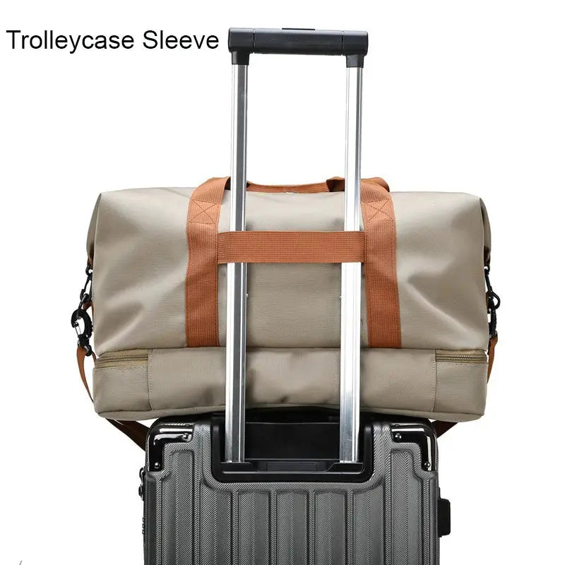 Travel gym bag atop a gray suitcase with orange straps and an extendable handle