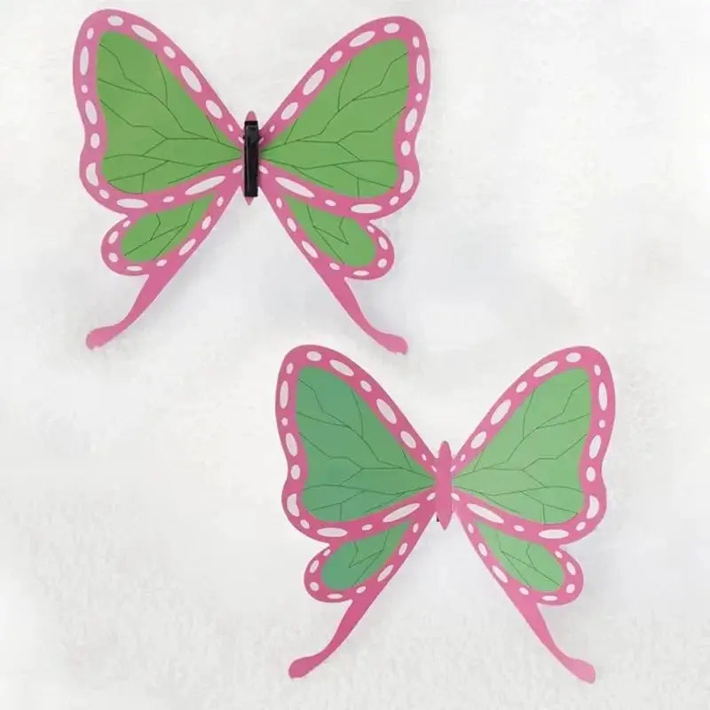 Two butterfly hair clips in pink and green with white dotted edges