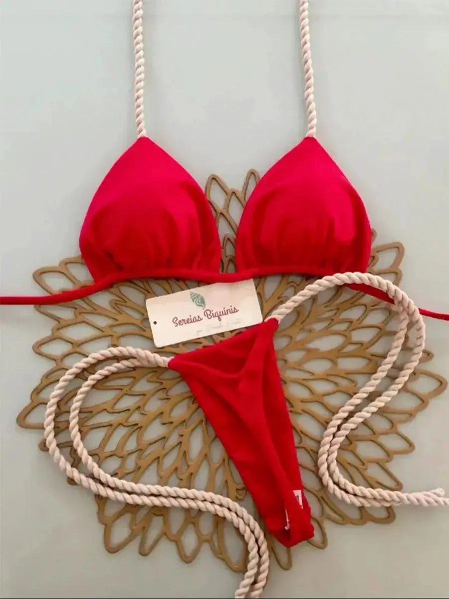 Bikini set red halter with thong bottom and rope straps on decorative background