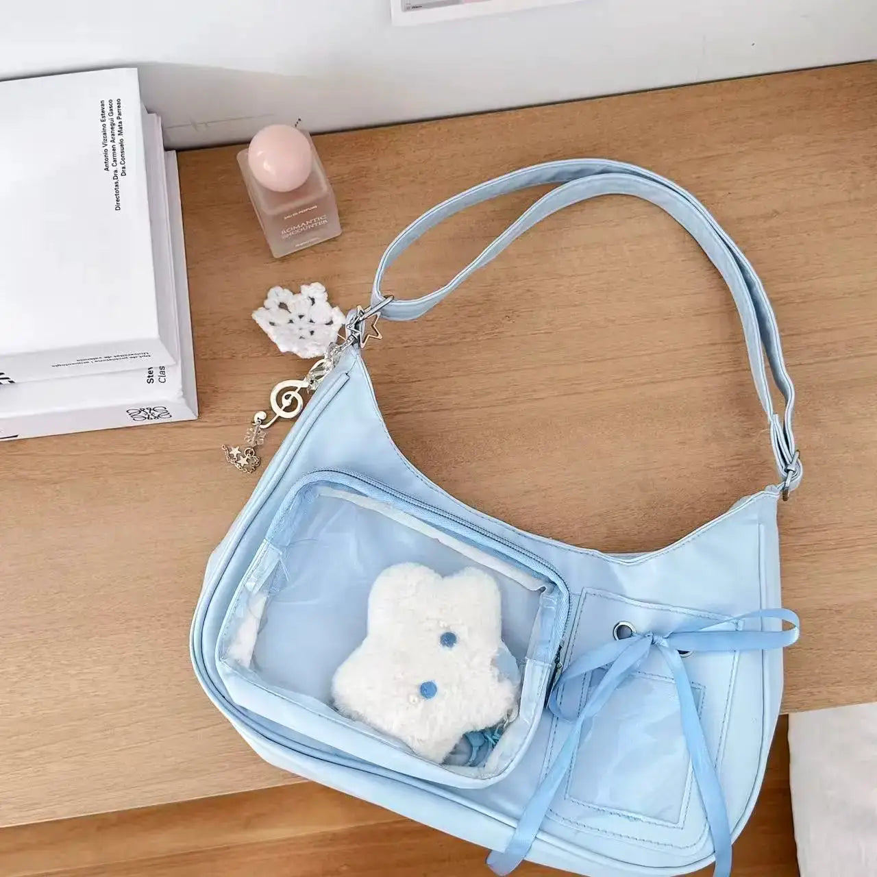 Light blue Y2K Harajuku transparent ita bag, shoulder bag with clear front pocket and plush teddy bear inside.