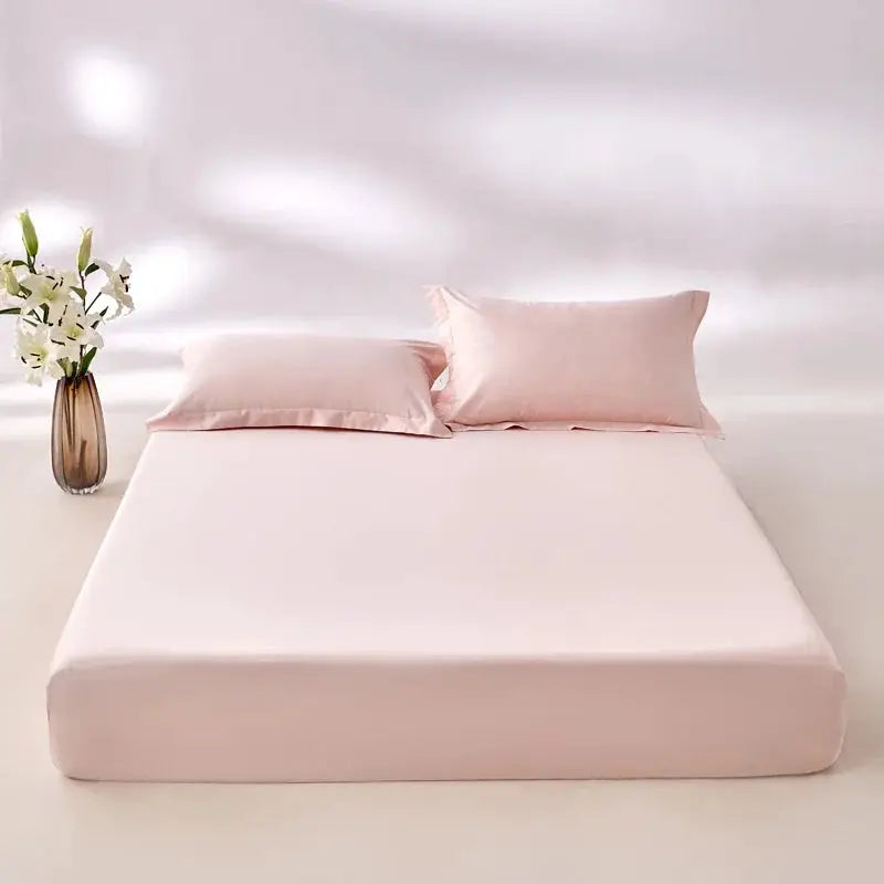 Egyptian cotton fitted sheet in blush pink (800TC) on bed with two pink pillows.