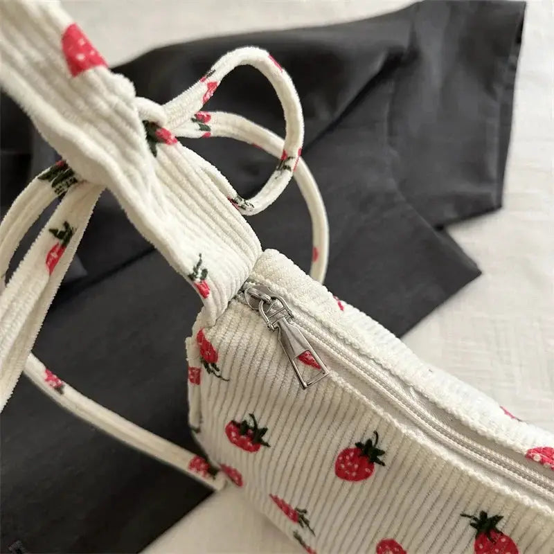 Corduroy strawberry-print mini underarm bag with zipper closure in cream color.