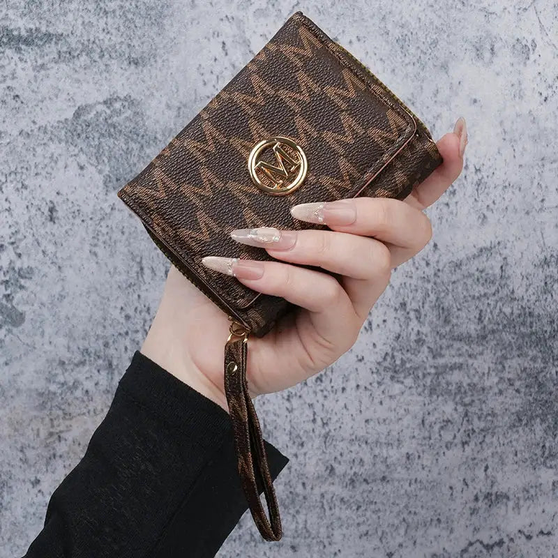 Small brown PU wallet by Simples Market with monogram print, gold circular logo, and wrist strap