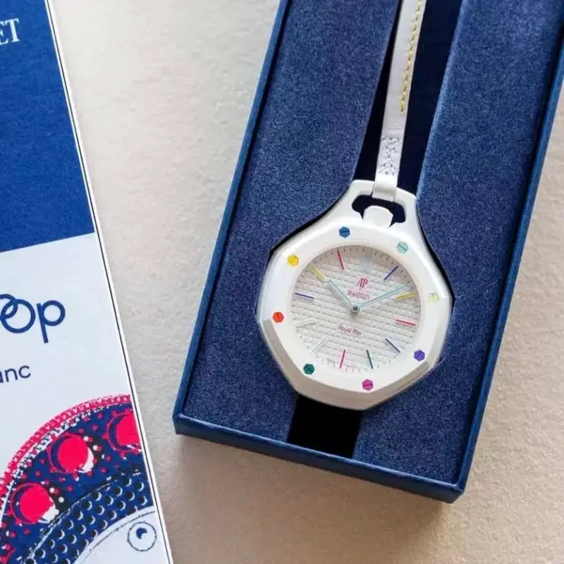 AP Swatch joint watch in white case with rainbow dial and white strap, in blue gift box
