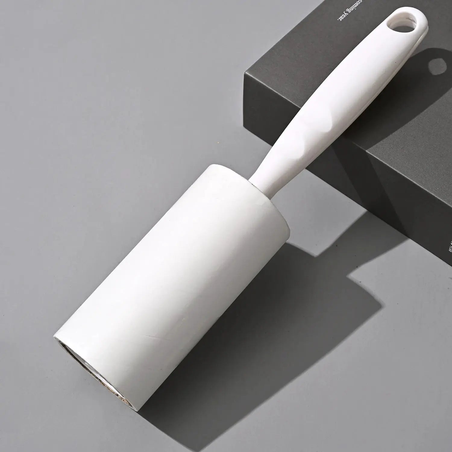 Lint roller with replaceable roll; white plastic handle and roller