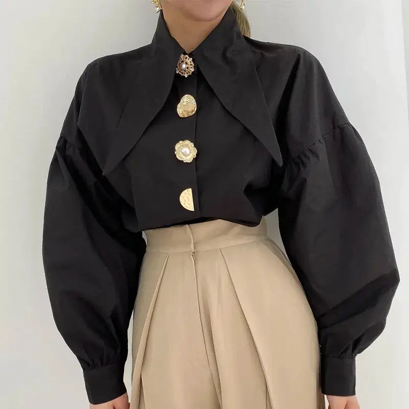 Black puff-sleeve blouse with sharp collar and pearl-button accents.