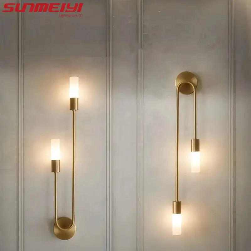 LED golden brass wall sconces with dual cylindrical frosted-glass shades; wall-mount pair by Simples Market