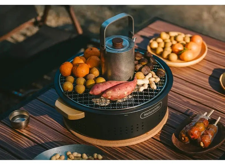 Naturehike outdoor tabletop BBQ stove, round black charcoal grill on a wooden base with veggies and skewers