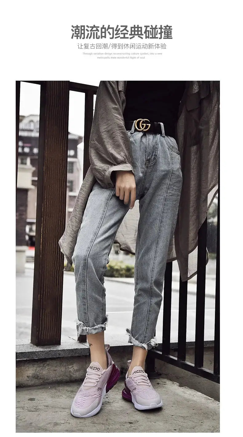 Men's lavender-pink mesh sneakers with white sole and breathable upper, worn by a model in light denim jeans and a Gucci belt.