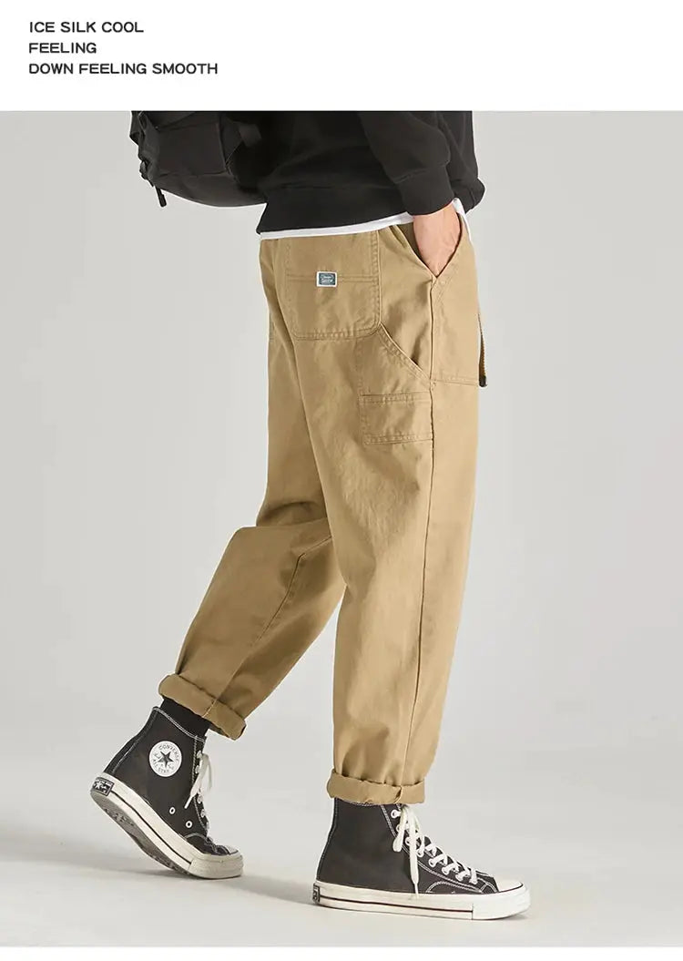 Men's khaki cargo pants with multiple pockets, baggy fit and rolled cuffs.