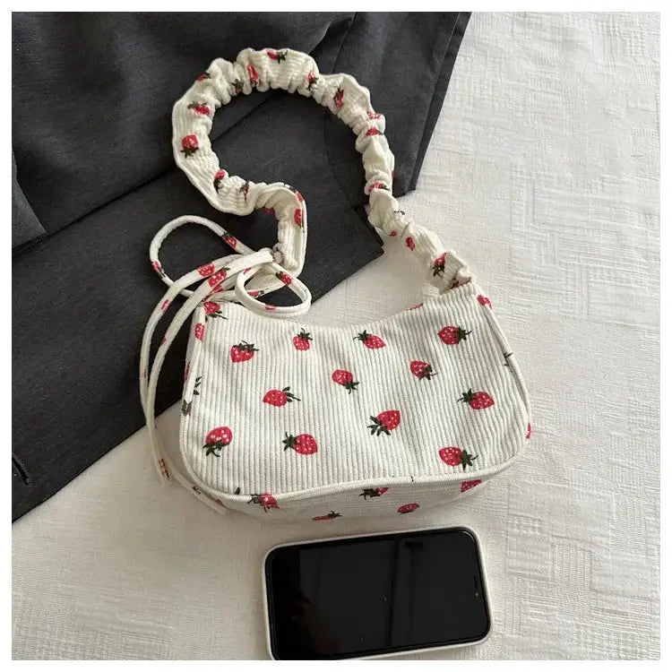 Cream corduroy underarm handbag with strawberry print, small half-moon purse and ruched strap.