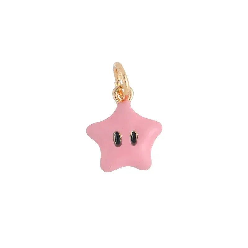 Pink star-shaped pendant with black eyes on a small gold-tone hoop earring.