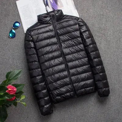 Men's black down jacket on gray surface, lightweight puffer coat