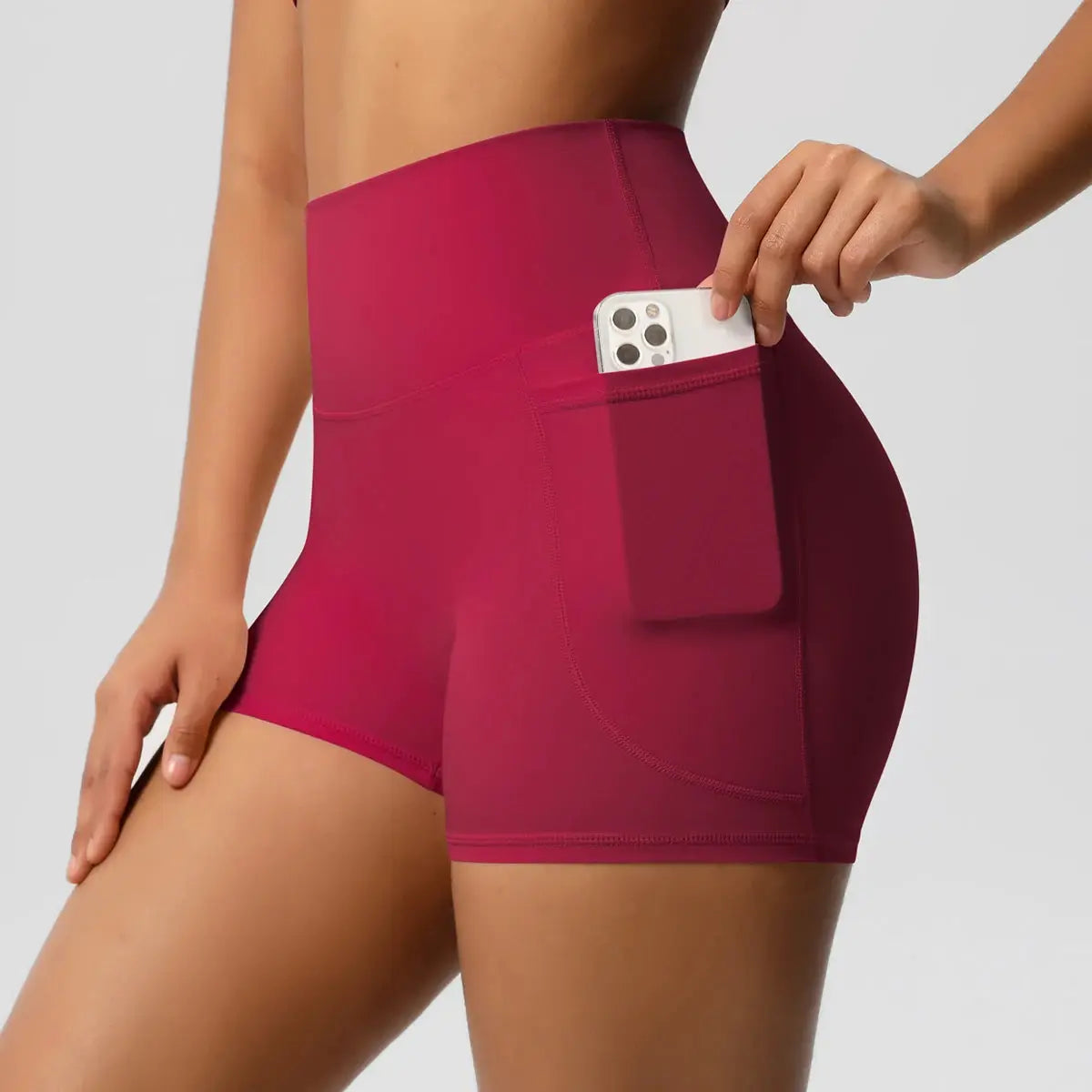 Women high-waist pocketed yoga shorts in magenta with side phone pocket