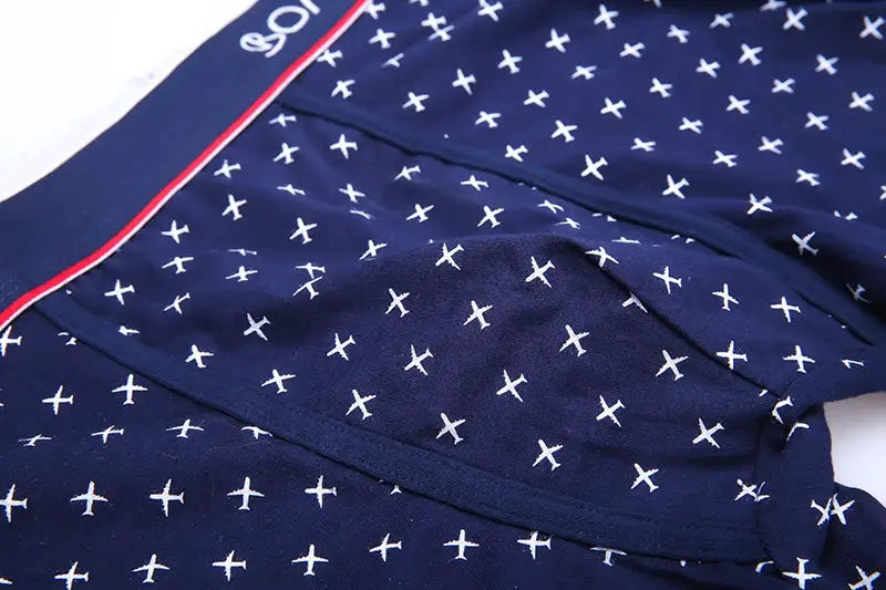 Navy blue cotton boxer shorts with white cross pattern and red waistband trim