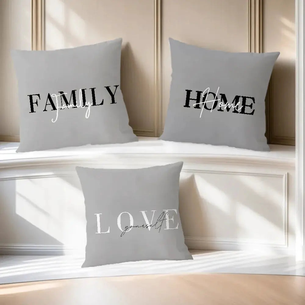 Pillow covers set of 3 in gray with decorative script text FAMILY, HOME and LOVE on a light backdrop.