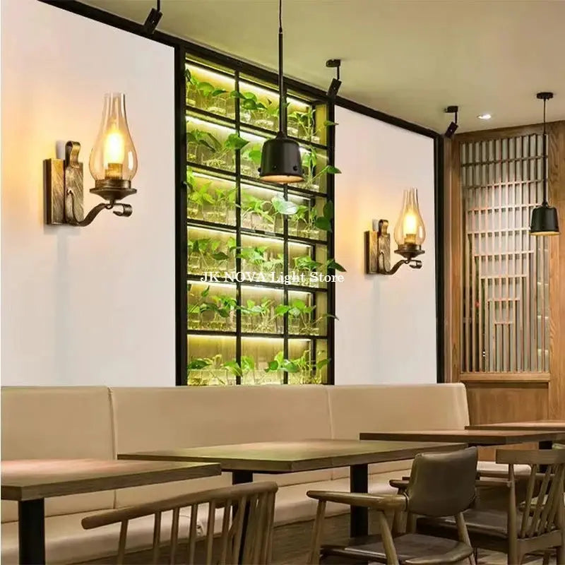 Pair of wrought-iron wall lamps with amber glass shades in a loft-industrial restaurant interior