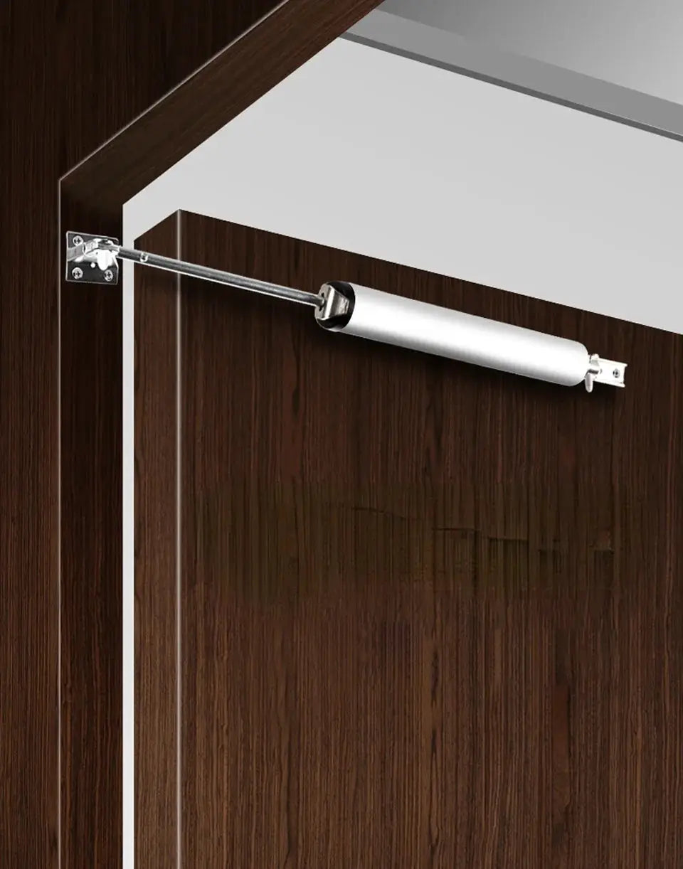Simples Market automatic door closer with white cylindrical body on dark wood door