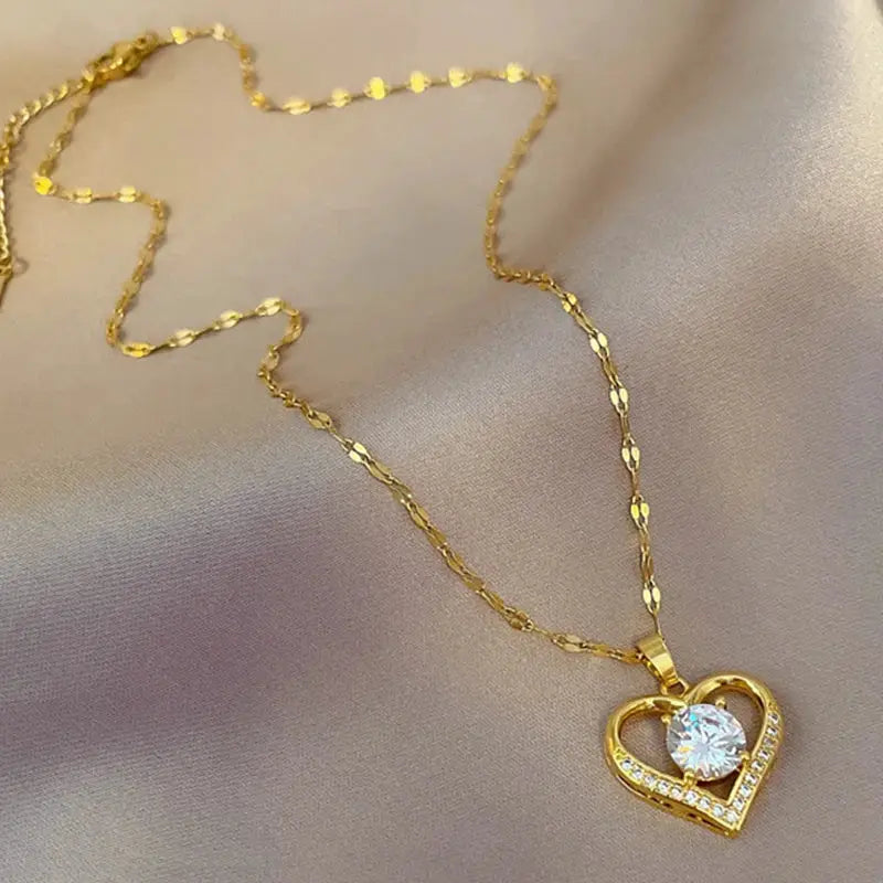 Gold-tone heart pendant necklace with a clear crystal centerpiece on a delicate chain
