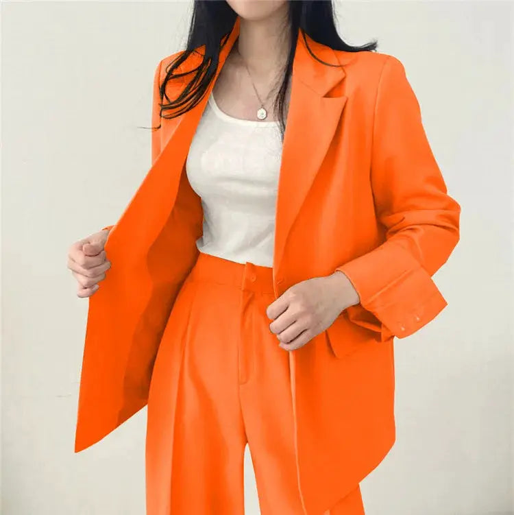 Two-piece orange blazer and pants set for women with a white top