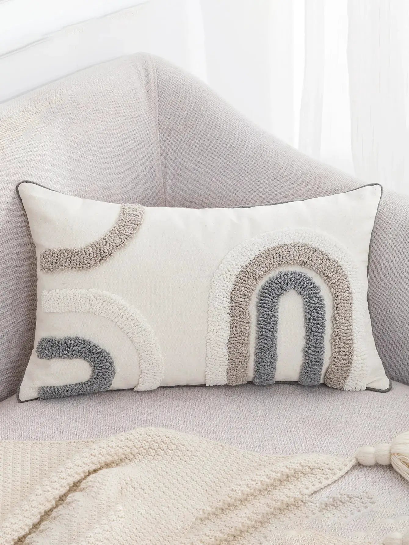Pillow cover with boho U-shaped tufted pattern in white, beige and gray.