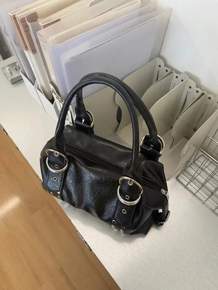 Shoulder bag in black PU leather with silver rivet hardware and top handles.