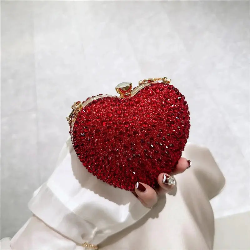 Red heart-shaped crystal clutch purse with gold-tone frame and chain, evening bag