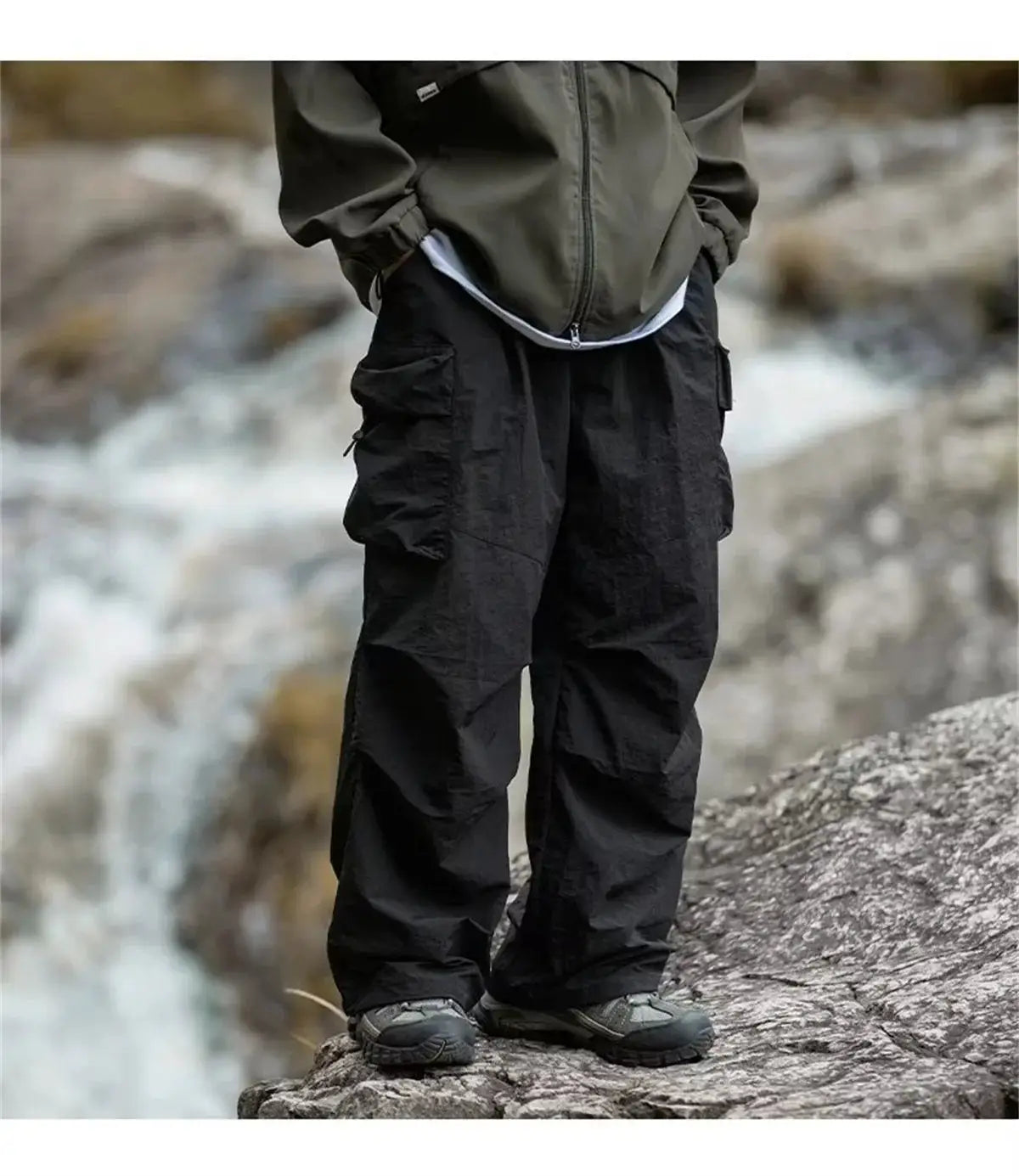 Men's black waterproof cargo mountaineering pants with multiple pockets.