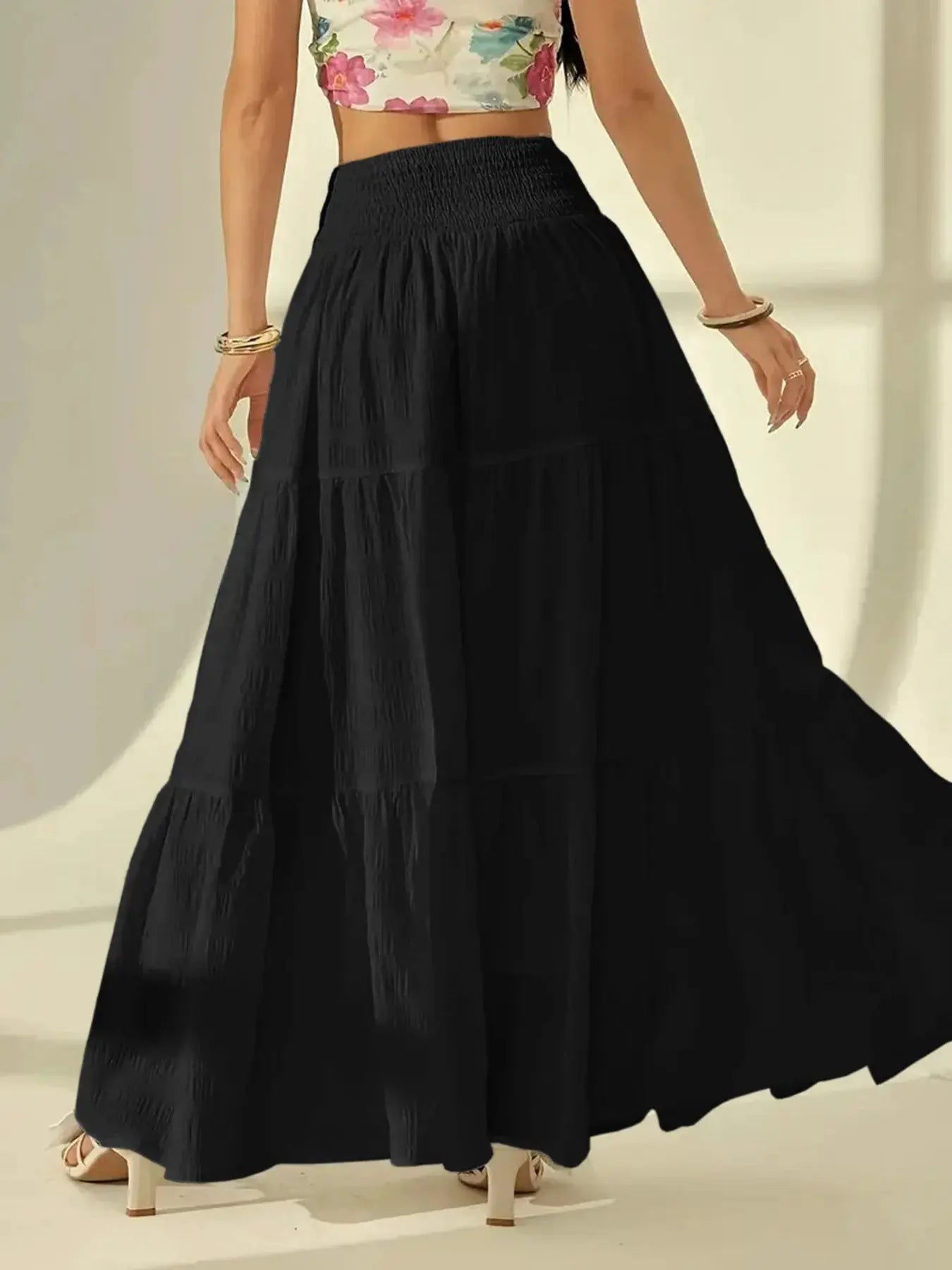 Black tiered maxi skirt with smocked elastic waistband and flowing pleated tiers