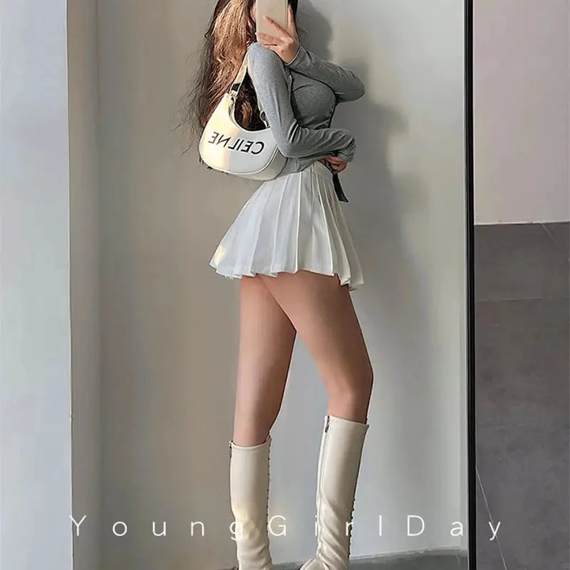 Pleated skirt with shorts, white mini high-waist A-line, paired with grey top and knee-high boots; CELINE bag
