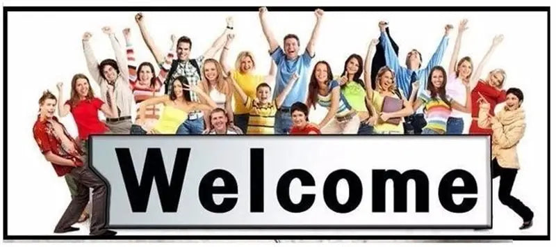 Group photo of diverse people posing behind a large Welcome banner