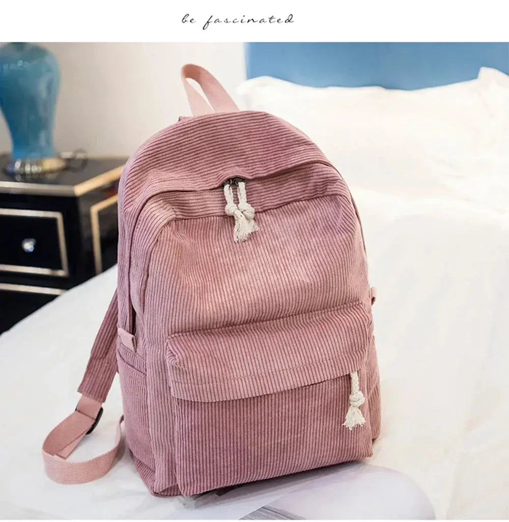 Corduroy student backpack in pink with front pocket and tassel zipper pulls