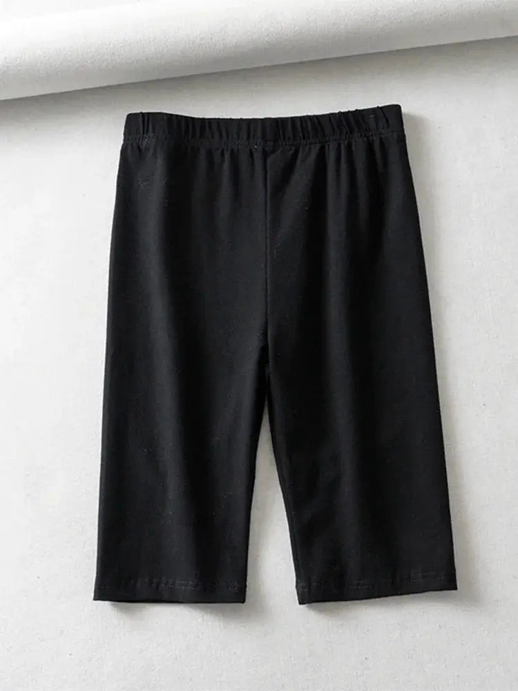 Knee-length black high-waist women's biker shorts with elastic waistband, solid color