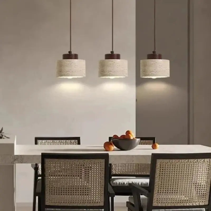 Led pendant lamp Yellow Cave Stone chandelier; three beige stone-textured pendant lights suspended over a dining table.