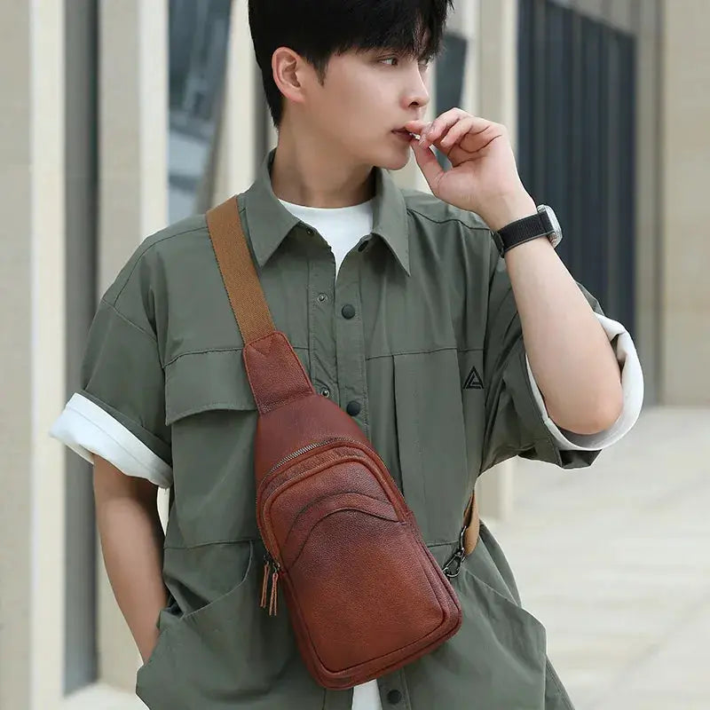 Chest bag in brown top-grain leather with dual zipper pockets and a crossbody strap