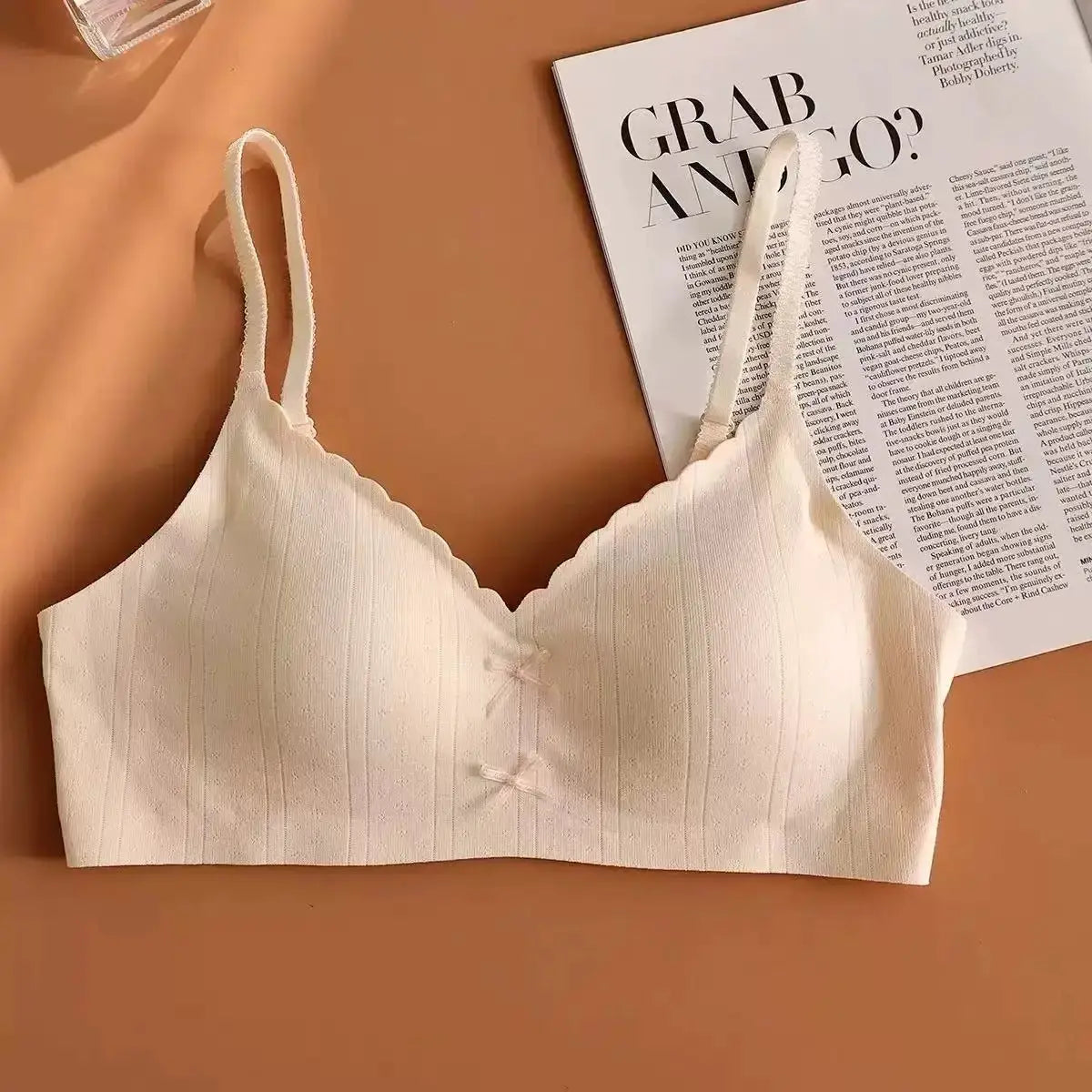 White ribbed bralette-style sports bra with scalloped edge, thin straps, no underwire, front bow detail.