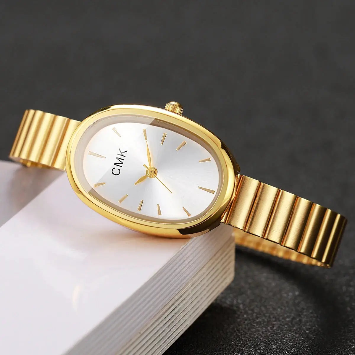 CMK gold-tone oval-dial women's watch with a slim metal band, analog quartz