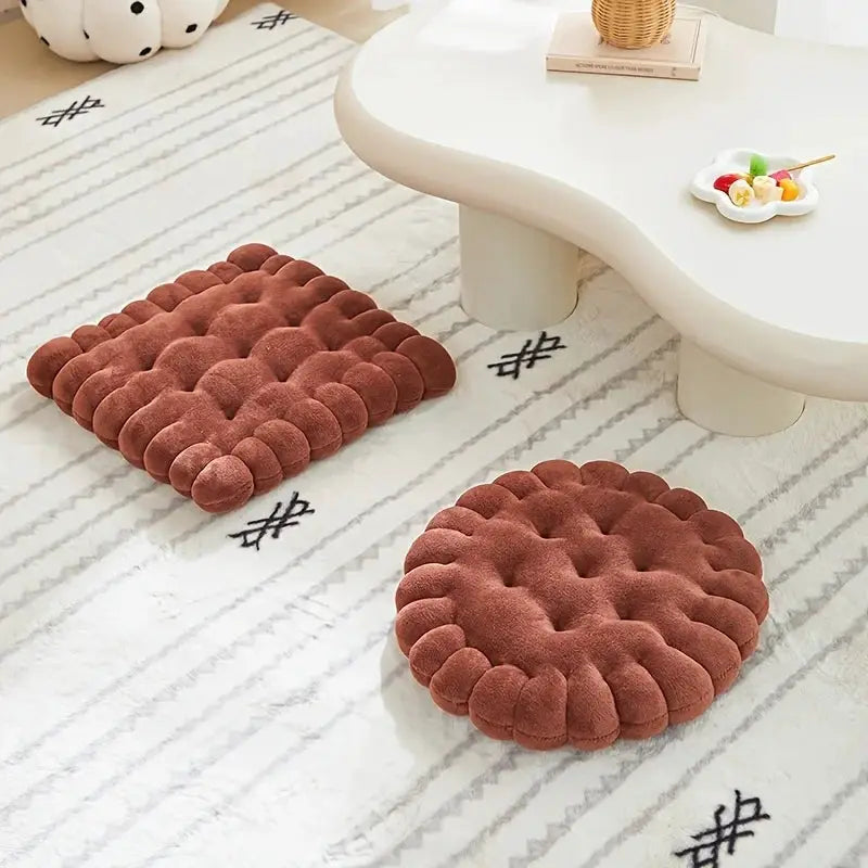 Two large biscuit-shaped plush cushions in brown with soft fabric on a light rug.