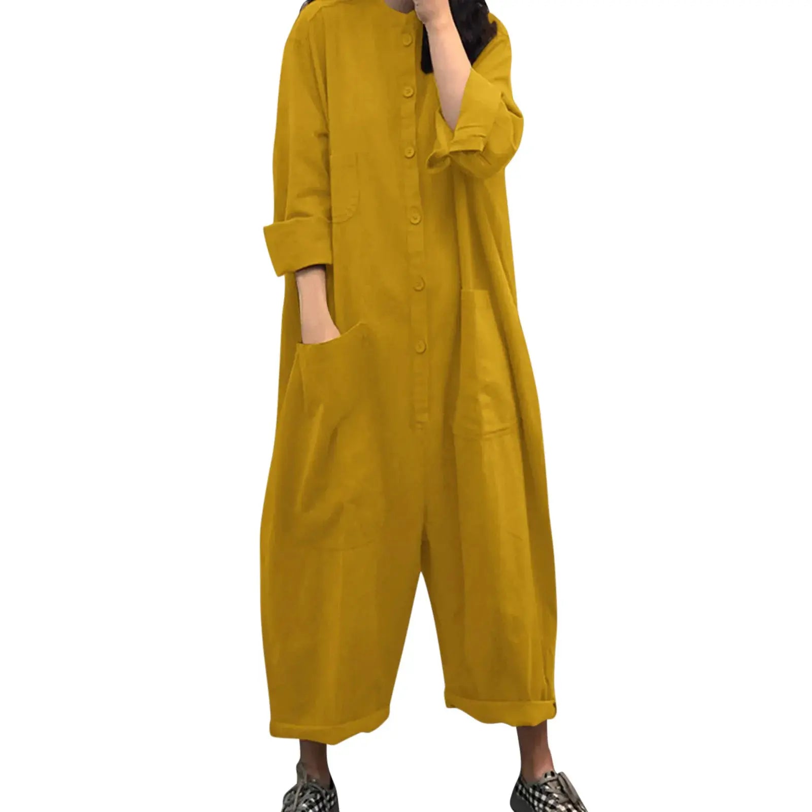 Mustard yellow loose-fit women’s jumpsuit with front buttons, patch pockets, long sleeves, and rolled cuffs