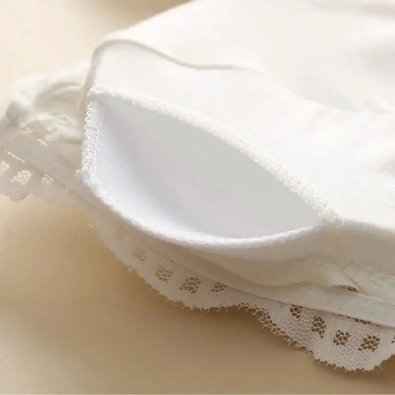 White lace bralette close-up with scalloped edge trim; wireless daily intimates.