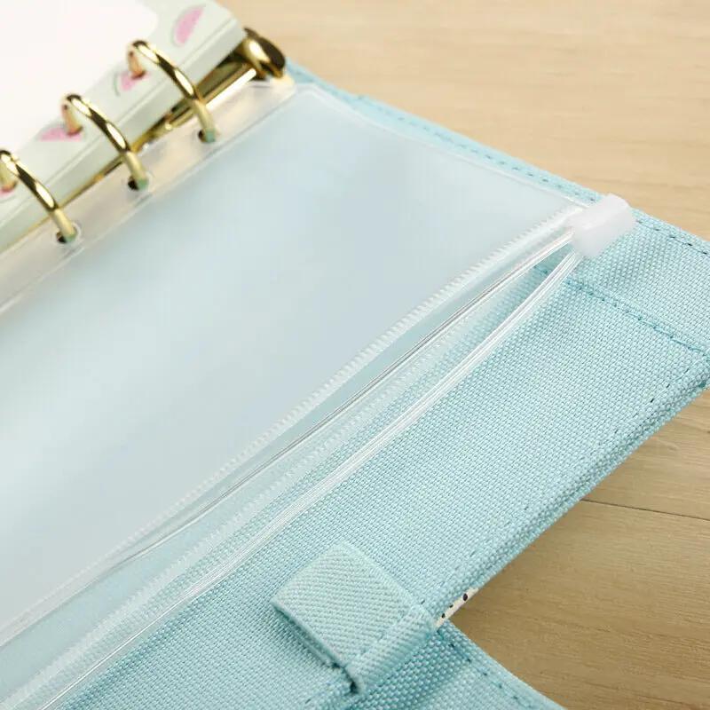 Light blue six-ring binder with a clear zippered PVC pocket on the inner cover