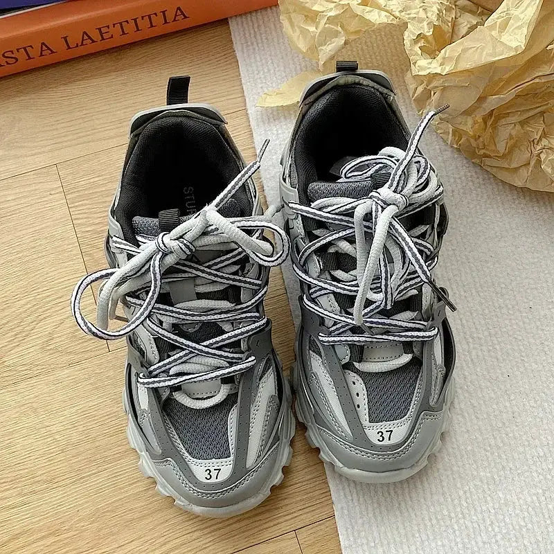 Chunky gray sneakers pair with white laces, casual sports shoes