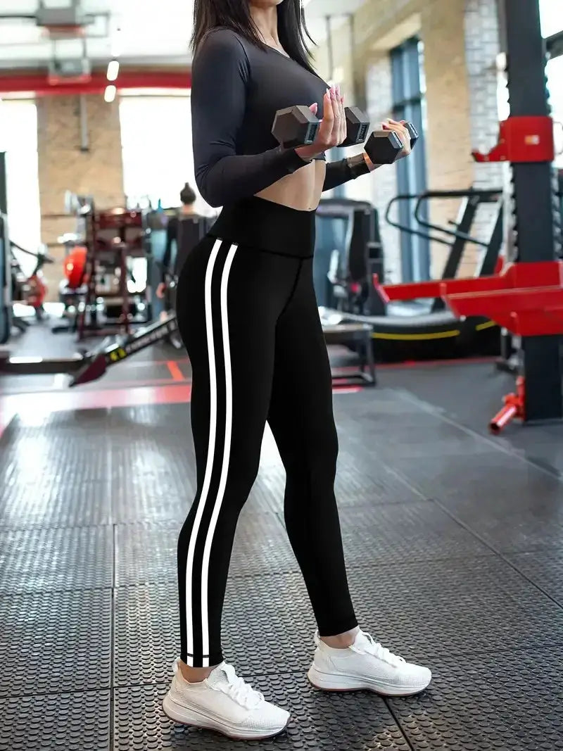 Women's high-waisted yoga leggings with white side stripes on black athletic pants