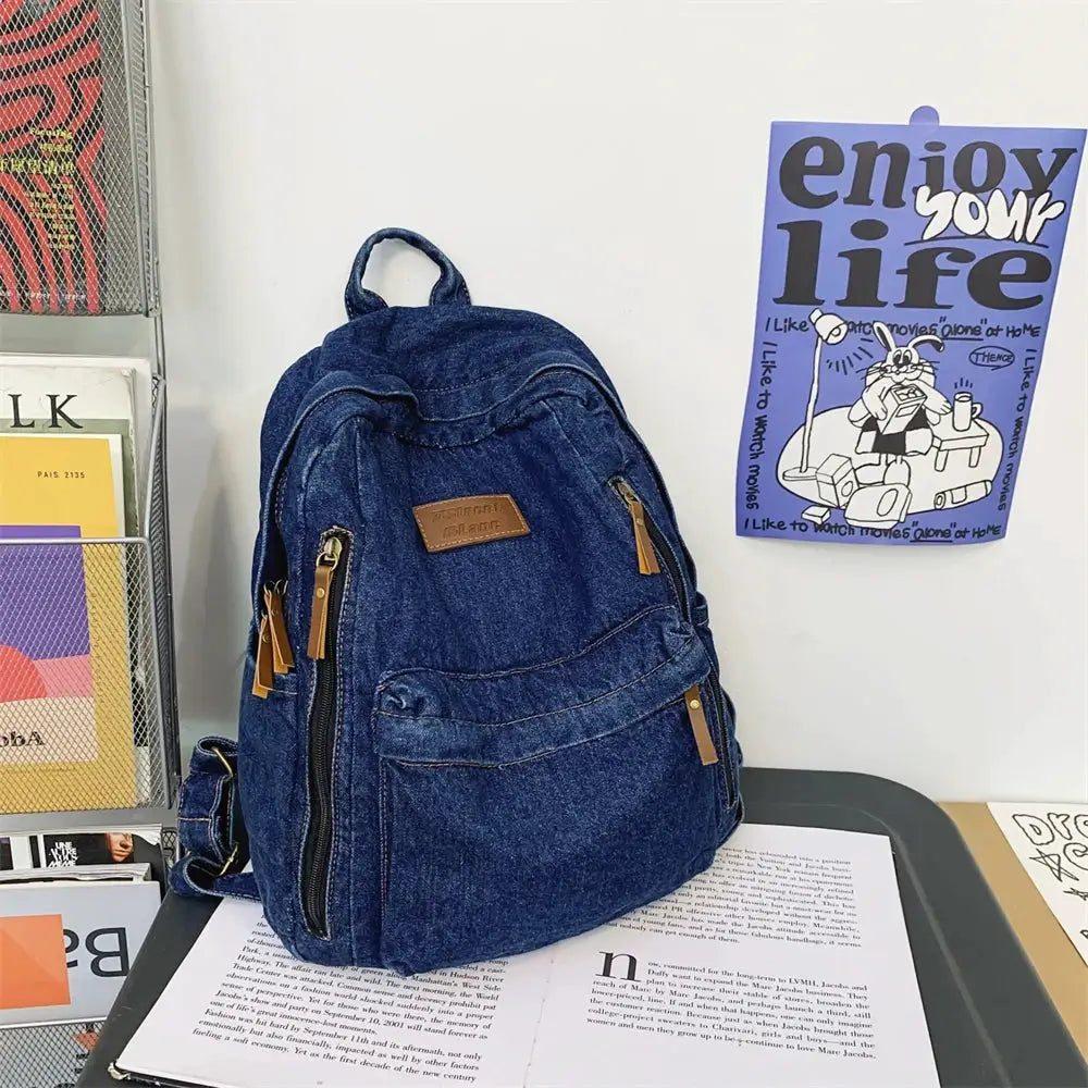 Denim backpack by Simples Market with multiple zip pockets and brown leather pulls