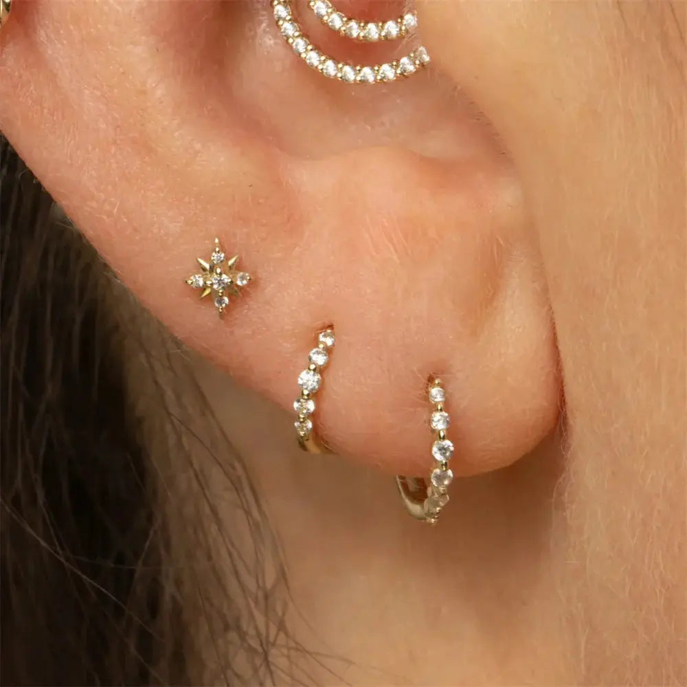 AIDE sterling silver star-shaped zircon stud and two diamond-studded hoops worn on the ear
